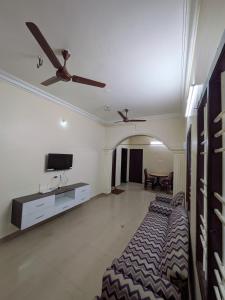 a bedroom with a bed and a flat screen tv at Sri Abirami Homestays in Tiruvannāmalai