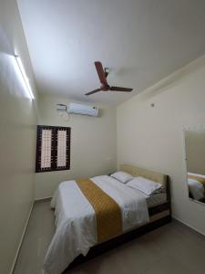 a bedroom with a bed with a ceiling fan at Sri Abirami Homestays in Tiruvannāmalai