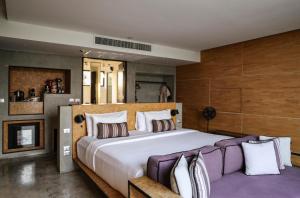 a bedroom with a large bed and a fireplace at The Xcape River Kwai in Kanchanaburi +24 photos