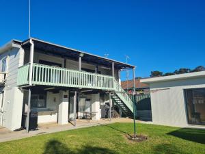 a house with a balcony and a staircase at Fishos Hangout 2 - Unit 2 Sinclair St 21 in Bermagui +8 photos