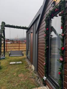 una casa con una corona de navidad a su lado en Peak View Tiny House, en Zărneşti