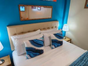 una camera da letto con pareti blu e un letto con cuscini di The Cat And The Kraken Paliton Jacuzzi Suites with Solar and Starlink a Siquijor