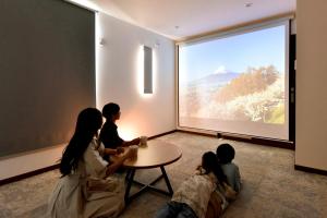 a group of people sitting around a table in front of a large window at Fuji Gran Villa - TOKI - in Fujiyoshida