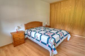 a bedroom with a bed and a nightstand with a bed sidx sidx sidx sidx at Casa das Gêmeas in Sabuzedo