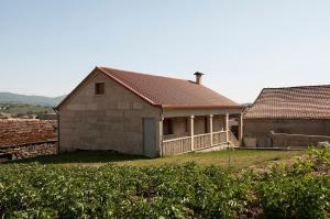 ein Haus mit einem Dach auf einem Feld in der Unterkunft Casa das Gêmeas in Sabuzedo