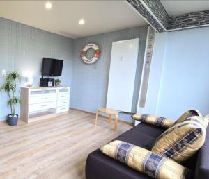 a living room with a couch and a tv at Ferienwohnung Seepferdchen in Schönberg +7 photos