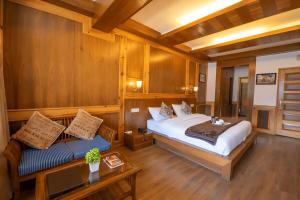 um quarto com uma cama e um sofá em uma sala em Vivaan The Sunrise em Manali mais 93 fotografias