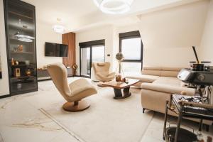 a living room with a couch and chairs and a tv at Grand Residence Zlatibor in Zlatibor