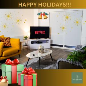 a living room with christmas presents and a tv at Manchester City Centre Apt, with Free Secured Parking & Balcony, Sleeps 4- HOLIDAY PROMO FOR CHRISTMAS AND NEW YEAR in Manchester