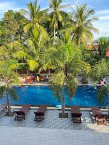 uma piscina com palmeiras e bancos ao lado de um resort em Don Falang Homestay- Private Island em Don Det