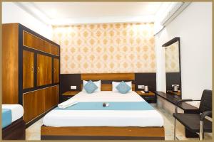 a bedroom with a large bed and a chair at Tulsi Nagar Colony Dawarikanath Nirmala # Palace Residency Near Ram-Janam-Bhoomi # Restaurant - Parking Available - Fully Air Conditioning Luxuary Room- A Top Rated Hotel In Ayodhya in Ayodhya