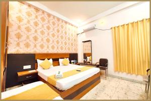 a hotel room with a large bed and a chair at Tulsi Nagar Colony Dawarikanath Nirmala # Palace Residency Near Ram-Janam-Bhoomi # Restaurant - Parking Available - Fully Air Conditioning Luxuary Room- A Top Rated Hotel In Ayodhya in Ayodhya +18 photos