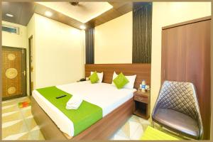 a bedroom with a bed and a chair in it at Tulsi Nagar Colony Dawarikanath Nirmala # Palace Residency Near Ram-Janam-Bhoomi # Restaurant - Parking Available - Fully Air Conditioning Luxuary Room- A Top Rated Hotel In Ayodhya in Ayodhya