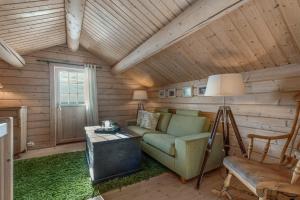 een woonkamer met een bank en een tafel bij Timber Cabin With Panoramic Views At Spåtind in Etnedal
