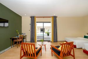 Una sala de estar con una cama, una mesa y sillas. en Vrest Hotel Otres Beach, en Sihanoukville