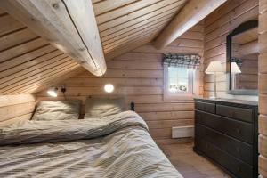een slaapkamer met een bed in een houten hut bij Timber Cabin With Panoramic Views At Spåtind in Etnedal