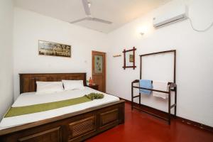 un dormitorio con una cama y un espejo en Surf Dine, en Matara