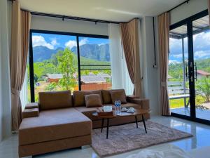 ein Wohnzimmer mit Sofa und Tisch in der Unterkunft Khaosok River Stone Resort & Camp in Ban Thung Lang Tham