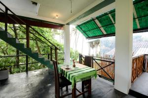 Una habitación con una mesa y sillas en un balcón. en Surf Dine, en Matara