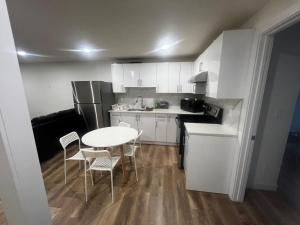 una pequeña cocina con mesa blanca y sillas en Private room in Basement suite, en Edmonton 16 fotos más
