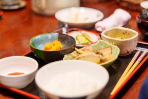 弘前市金剛山最勝院 寺泊的桌子上放着一个托盘，上面摆着几碗食物和筷子。