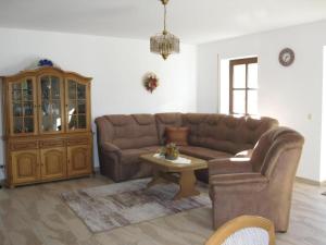 a living room with a brown couch and a table at Fehaus Johannesberg in Waltershausen