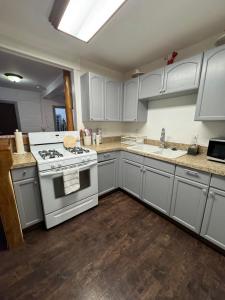 a kitchen with white cabinets and a stove at Snuggle Inn Cabin in Running Springs