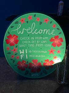 a green plate with a sign with flowers on it at This is OKINAWA in Motobu