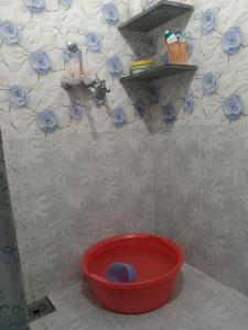 ein roter Eimer in einem Badezimmer mit Waschbecken in der Unterkunft ganga kashi niwas in Varanasi