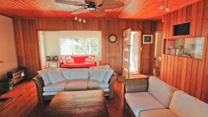 un soggiorno con divani e ventilatore a soffitto di Lakehouse Akolele 19 Flower Circuit- Wallaga Lake Bermagui a Central Tilba