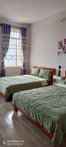 a bedroom with two beds and a window at Thuy's homestay in Vung Tau