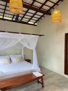 Calm Aruna Boutique Lodge - Mirissa في ميريسا: غرفة نوم مع سرير مع مظلة واضاءين +23 صورة