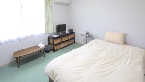 Una cama o camas en una habitación de ゲストハウスガーデンズmihama