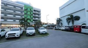 een parkeerplaats met auto's geparkeerd voor een gebouw bij D' Leonor Hotel in Cabaguio