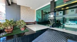 a lobby of a building with potted plants in it at Laemchabang City Hotel in Ban Thung Sukla