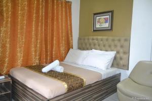 um quarto de hotel com uma cama e uma cadeira em Zanrock Micro Hotel em Lagao III mais 53 fotografias