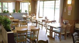 um restaurante com mesas e cadeiras em uma sala em Otaiko Hills em Ito