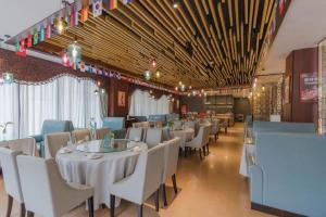 a dining room with white tables and chairs at Bati Holiday Hotel in Zhongshan