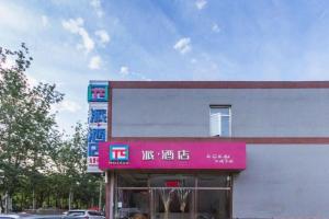 um edifício com um sinal rosa na lateral em PAI Hotel Beijing Capital International Airport Linhe Development Zone em Tahe