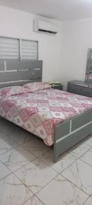 a bedroom with a bed with a pink comforter at Jeremi Apartamentos in Colorado