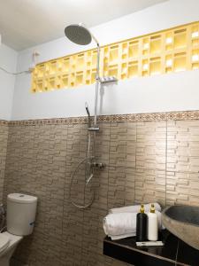 MantaakLumbung Lodge Lovina的带淋浴、马桶和水槽的浴室