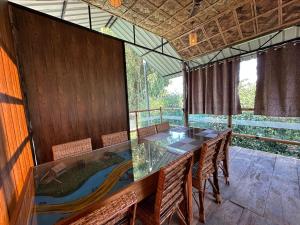 a dining room with a glass table and chairs at Kaziranga Tea Nest Homestay in Kāziranga +58 photos