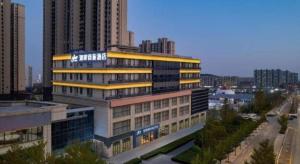 a building with a sign on it in a city at Echarm Hotel Jinan West Station International Exhibition Center in Jinan