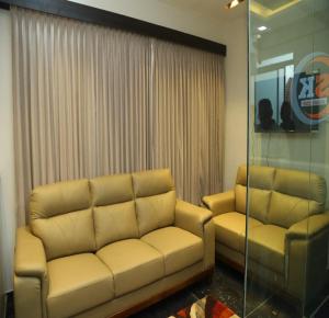 ein Wohnzimmer mit einer Couch und zwei Sesseln in der Unterkunft SK Home Stay in Mayiladuthurai