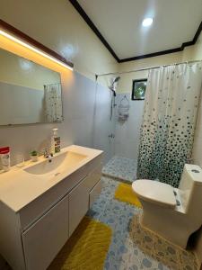 un bagno con lavandino, WC e doccia di Oceana a Padre Burgos