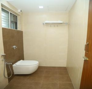 ein kleines Badezimmer mit Toilette und Fenster in der Unterkunft SK Home Stay in Mayiladuthurai