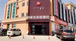 two cars parked in front of a building at Thank Inn Hotel Inner Mongolia Baotou Donghe Haode Trade Plaza in Baotou