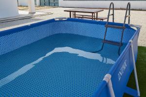 a small blue swimming pool with a table and a picnic table at De'5 Tiny House , Besut in Kampong Kubang Bemban