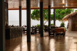 a restaurant with tables and chairs and a view of the ocean at Dream Team Beach Resort in Ko Lanta