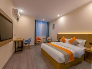 a hotel room with a bed and a tv at Shell Hotel Wuxi Gonghu Avenue Vientiane City in Zhongqiao